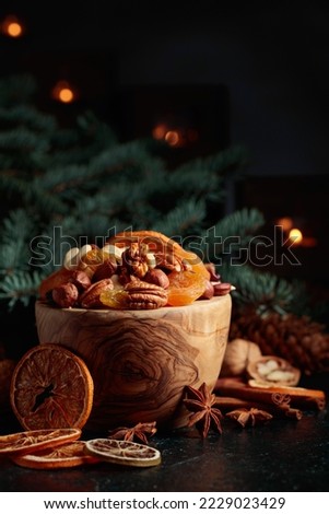 Dried fruits and assorted nuts. Christmas still-life with spruce branches and burning candles.