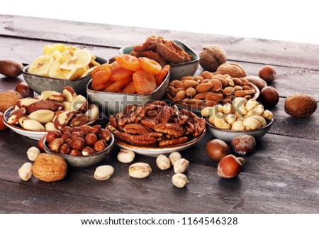 dried fruits and assorted nuts composition on rustic table.
