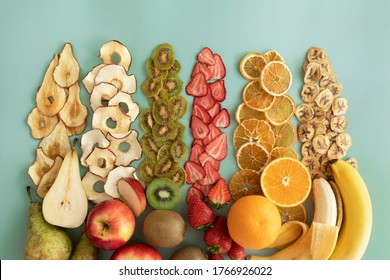 Dried fruits and fruit chips along with the fresh fruit of which they are made. Dietary nutrition. Natural and healthy snack food.