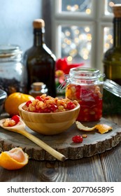 Dried Fruits And Raisins Soaked In Spices In Rum, For Traditional Christmas Fruit Cake In A Bowl And Jar Against The Background Of A Window With Christmas Lights. Concept Of Winter Holidays.