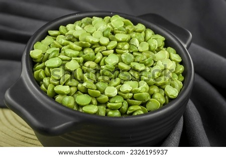 Dried green split peas in a ceramic bowl  on gray background.