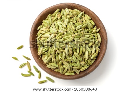 dried herb, fennel seeds in the wooden plate, isolated on white, top view