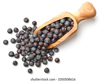 dried juniper berries in the olive wooden scoop, top view