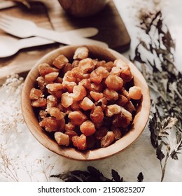 Dried Longan in a wooden bowl, Dried Longan is simply the product of fresh longan, dried, shelled and pitted, reserving the meaty flesh inside.