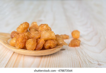 dried longan with wooden spoon and table background