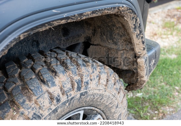 Dried mud on SUV\'s off-road mud tires. Close up\
low angle view, no\
people.