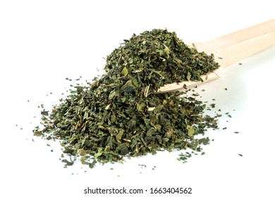 dried nettle herb or in latin Utricae folium in wooden spoon isolated on white background. medicinal healing herbs. herbal medicine. alternative medicine