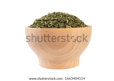 dried nettle herb or in latin Utricae folium in wooden bowl isolated on white background. medicinal healing herbs. herbal medicine. alternative medicine