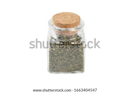 dried nettle herb or in latin Utricae folium in a glass jar isolated on white background. medicinal healing herbs. herbal medicine. alternative medicine