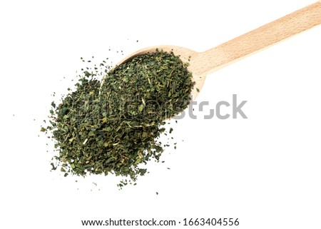 dried nettle herb or in latin Utricae folium in wooden spoon isolated on white background. medicinal healing herbs. herbal medicine. alternative medicine