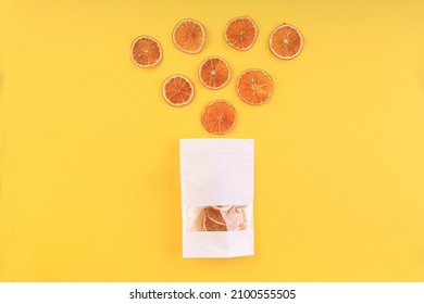 Dried Orange Slices Coming Out Of A Bag On A Yellow Background