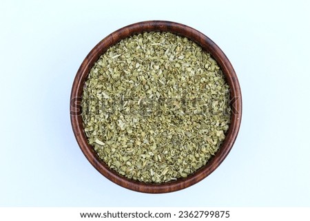 Dried Oregano spice in a wooden bowl top view 