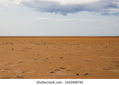 Dried Out Coast With Damp Reddish Brown Sand. Water Receded, Looks Almost Like Mars