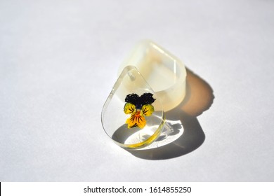 Dried Pansy Flower In Epoxy Resin Tear Drop. White Silicone Mold Isolated On White Background. Handmade Jewelry.