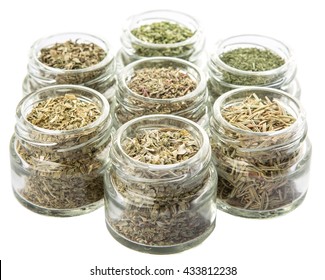 Dried parsley, estragon, marjoram, dill weed, thyme, rosemary and basil herbs in mason jar over white background