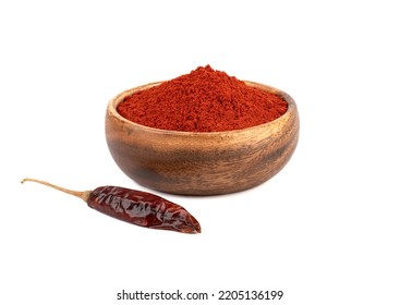 Dried peppercorns and ground smoked red paprika in a wooden bowl on a white background. Condiments and spices.