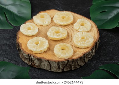 Dried pineapple rings on wooden piece. High quality photo
