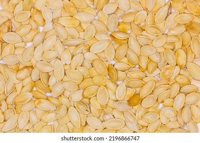 Dried Pumpkin Seeds In Husks. Yellow Pumpkin Seeds. Wallpaper, Background. Flat Oval Seed Of Squash. Edible Seed Of A Pumpkin. Healthy Food. Natural Product. Roasted Snack. Pepita. Top View. Close-up