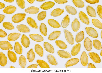 Dried Pumpkin Seeds In Husks. Yellow Pumpkin Seeds On A White Background. Isolated. Flat Oval Seed Of Squash. Edible Seed Of A Pumpkin. Healthy Food. Natural Product. Roasted Snack. Pepita. Close-up