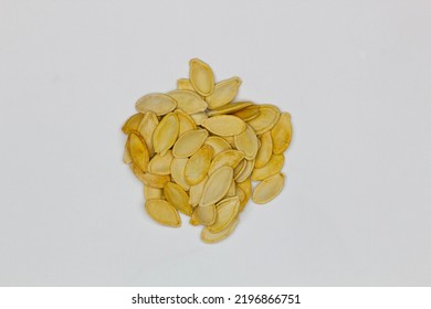 Dried Pumpkin Seeds In Husks. Yellow Pumpkin Seeds On A White Background. Isolated. Flat Oval Seed Of Squash. Edible Seed Of A Pumpkin. Healthy Food. Natural Product. Roasted Snack. Pepita. Close-up