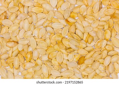 Dried Pumpkin Seeds In Husks. Yellow Pumpkin Seeds. Wallpaper, Background. Flat Oval Seed Of Squash. Edible Seed Of A Pumpkin. Healthy Food. Natural Product. Roasted Snack. Pepita. Top View. Close-up