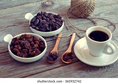 Dried Raisins Turkish And Spanish (Malaga). Turkish Raisins, Sultan Raisins Pitted . Raisins From Malaga With Stones. Dried Raisins On The Wood Backgraund, With A Cup Of Coffee.