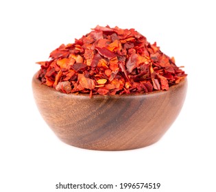 Dried Red Chili Flakes In Wooden Bowl, Isolated On White Background. Chopped Chilli Cayenne Pepper. Spices And Herbs.