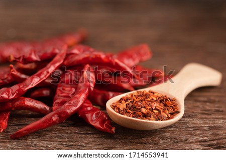 Dried red chili on wooden table.Chili powder on a wooden spoon