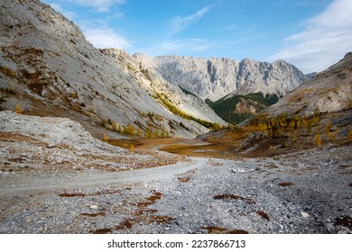 Dried up river bed in a rural countryside with the mountains in the background. Majestic landscape with the rock road and hills. - Powered by Shutterstock