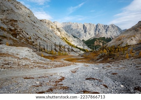 Dried up river bed in a rural countryside with the mountains in the background. Majestic landscape with the rock road and hills.