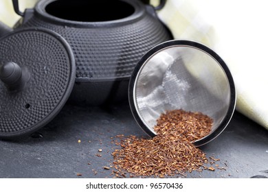 Dried Rooibos Tea Leaves Beside Teapot.