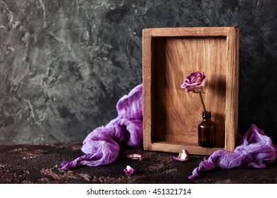 Dried Rose In A Mini Vase In Wooden Box On A Dark Background