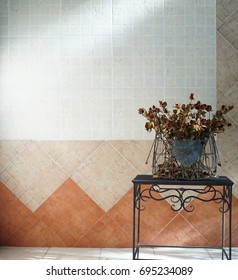 Dried Roses In A Black Irony Basket Set On A Coffee Table With White, Brown And Orange Brick Wall Background