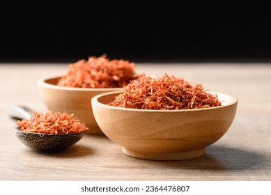 Dried safflower in wooden bowl and spoon, Herbal tea