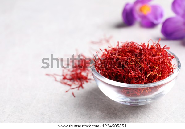 Dried saffron and crocus flowers on grey table,\
closeup. Space for text