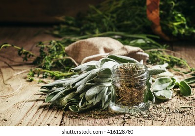 Dried sage in a glass jar, fresh sage on the vintage wooden table, preparation of medicinal herbs drying, selective focus