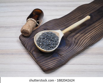 Dried Seaweed Laminaria In A Wooden Spoon And Drinking Kelp Extract In A Bottle On A Wooden Kitchen Board, Flat Layout. Useful Kale With Iodine For Use In Food And Cosmetology