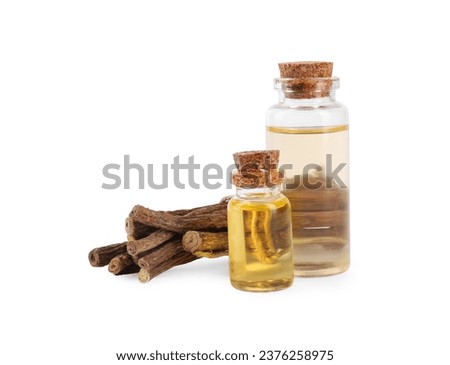 Dried sticks of licorice root and essential oil isolated on white