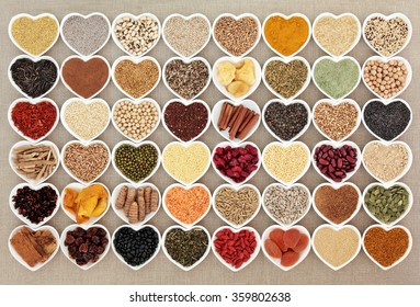 Dried super health food in heart shaped bowls over hessian background. High in minerals, vitamins and antioxidants.