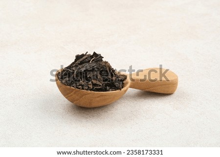 Dried tea leaves served on wooden spoon, copy space