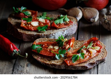 Dried Tomatoes Bread With Oil, Garlic And Parsley, Autumn Traditional Italian Food - Bruschetta Or Antipasti, Closeup, Healthy Vegan Food And Simple Living, Rustic Aesthetics Concept