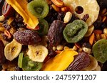 Dried tropical fruits with various nuts and raisins, macro shot, top view.