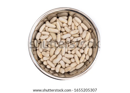 Dried White Beans from above in a stainless steel bowl, isolated on a white background. Healthy ingredient used in soups and casseroles. Naturally preserved legumes with long shelf life.