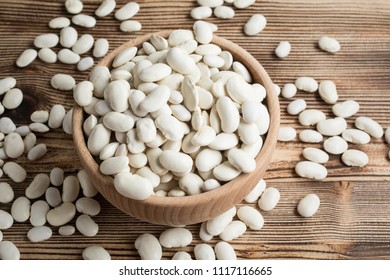 Dried White Beans In A Wooden Bowl.