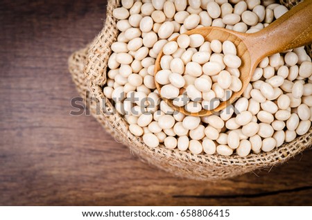 Dried White Beans with wooden spoon in sack bag on wooden background. Stock foto © 