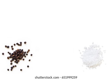 Dried Whole Seed Of Black Pepper And White Coarse Sea Salt Isolated On A White Background Seen From Above