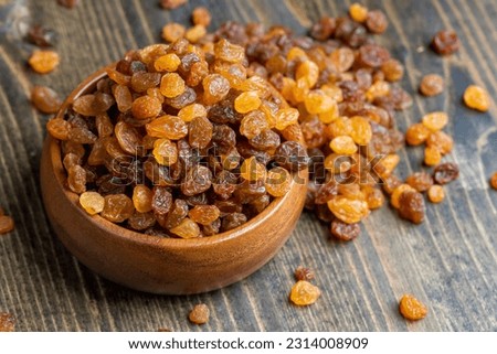 Dried yellow golden raisins on a board, a pile of hard sweet and dry raisins for dessert
