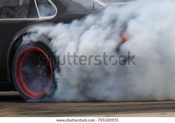 drift car motion spin rotating tire wheel with\
white smoke on the road.