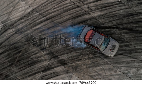 Drifting car, Aerial view drifting car on race
track, Abstract texture and background black tire tracks skid on
asphalt road, Wheel tire tracks background, Car tire track skid
mark on race track.