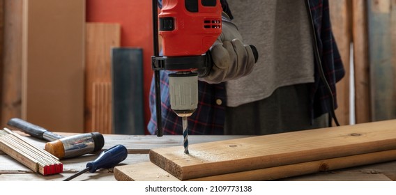 Drill Electric Tool, Carpenter Hand Drilling Wooden Plank. Construction Industry, Work Bench Table Closeup View